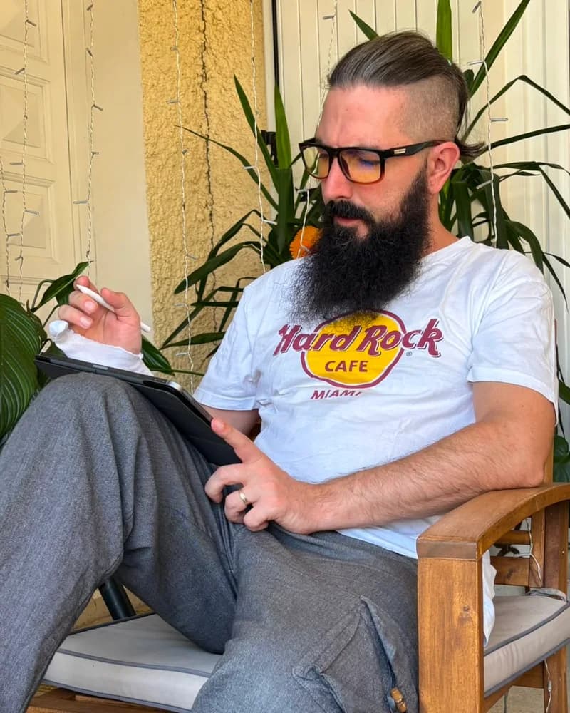 Florian Gimbert, assis sur sa terrasse, en train de travailler sur sa tablette